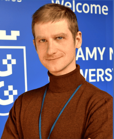 Uczestnik konferencji PHD RISK Summer School, młody naukowiec w rozmowie, w tle logo wydarzenia i napis "Welcome".